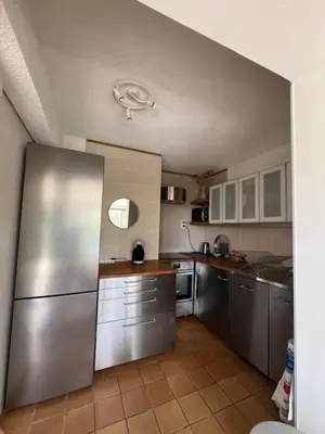 a large kitchen with a stainless steel refrigerator at Villa de charme avec piscine privée au sel in Gruissan