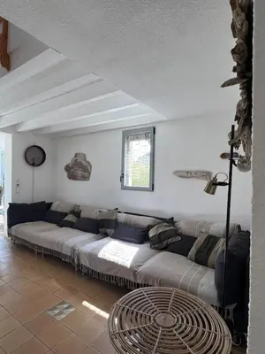a living room with a couch and a window at Villa de charme avec piscine privée au sel in Gruissan