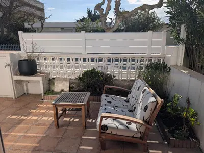 a patio with two chairs and a table and a fence at Appartement climatisé vue mer - 4 pers. - FR-1-797-65 in Port-la-Nouvelle