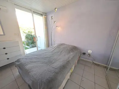 a bedroom with a bed and a large window at Appartement climatisé vue mer - 4 pers. - FR-1-797-65 in Port-la-Nouvelle