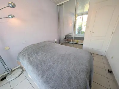 a bedroom with a bed and a mirror and a door at Appartement climatisé vue mer - 4 pers. - FR-1-797-65 in Port-la-Nouvelle