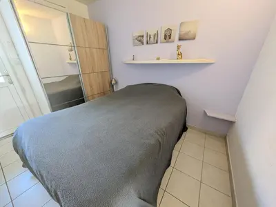 a small bedroom with a bed and a bathroom at Appartement climatisé vue mer - 4 pers. - FR-1-797-65 in Port-la-Nouvelle