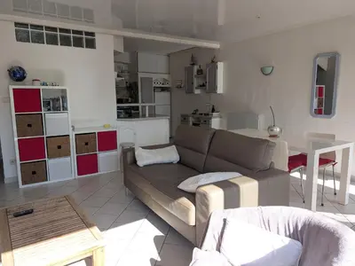 a living room with a couch and a kitchen at Appartement climatisé vue mer - 4 pers. - FR-1-797-65 in Port-la-Nouvelle