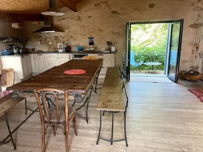 a kitchen with a large wooden table and chairs at Charming house in Tournissan