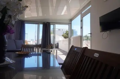 a room with two sliding glass doors and a dining room at Big 8 at Beach Clim Mer Terrace for 6 in Port-la-Nouvelle