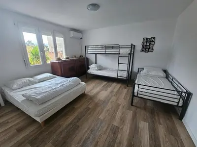 a living room with a bed and a table at Big 8 at Beach Clim Mer Terrace for 6 in Port-la-Nouvelle