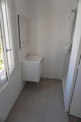 a white bathroom with a sink and a window at Big 8 at Beach Clim Mer Terrace for 6 in Port-la-Nouvelle