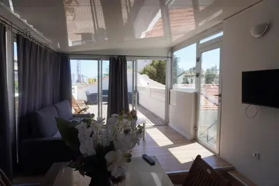 a living room with a vase of flowers on a table at Big 8 at Beach Clim Mer Terrace for 6 in Port-la-Nouvelle