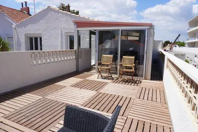 a wooden deck with chairs on a balcony at Big 8 at Beach Clim Mer Terrace for 6 in Port-la-Nouvelle