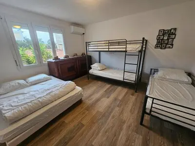 a bedroom with two bunk beds and a window at Big 8 at Beach Clim Mer Terrace for 6 in Port-la-Nouvelle