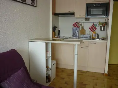 a small kitchen with a counter in a room at Studio cabine – 2 couchages – Vue port – Résidence Le Chébeck – Gruissan in Gruissan