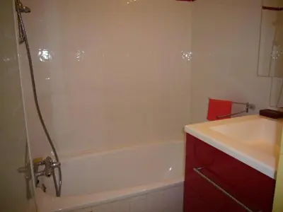 a bathroom with a white tub and a sink at Studio cabine – 2 couchages – Vue port – Résidence Le Chébeck – Gruissan in Gruissan
