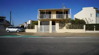 a house with a car parked in front of it at AIG 55 – Chalet individuel – Avenue de la Jetée – Gruissan – 6/7 personnes in Gruissan