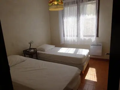 a bedroom with two beds and a window at AIG 55 – Chalet individuel – Avenue de la Jetée – Gruissan – 6/7 personnes in Gruissan