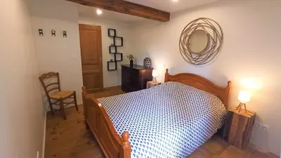 a bedroom with a bed and a mirror on the wall at Gîte Un Air d'Autan, labelissé 3 étoiles in Saint-Félix-Lauragais