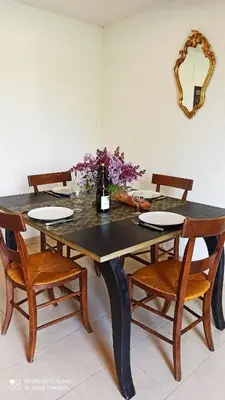 a dining room table with chairs and a bottle of wine at Gîte Un Air d'Autan, labelissé 3 étoiles in Saint-Félix-Lauragais
