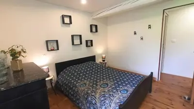 a bedroom with a bed with a blue and white bedspread at Gîte Un Air d'Autan, labelissé 3 étoiles in Saint-Félix-Lauragais