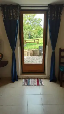 a door leading to a patio with a view of a yard at Gîte Un Air d'Autan, labelissé 3 étoiles in Saint-Félix-Lauragais