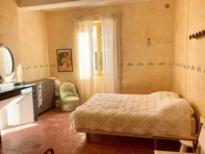 a bedroom with a bed and a dresser and a chair at AIG 63 – Grande maison de village avec Wi-Fi – Gruissan – 13 personnes in Gruissan