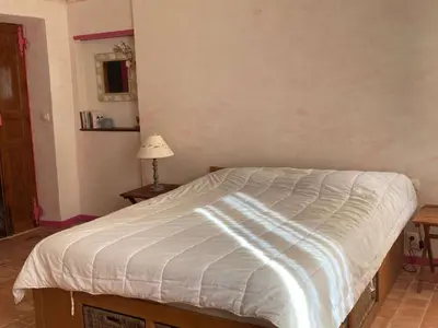 a bedroom with a bed with a white comforter at AIG 63 – Grande maison de village avec Wi-Fi – Gruissan – 13 personnes in Gruissan