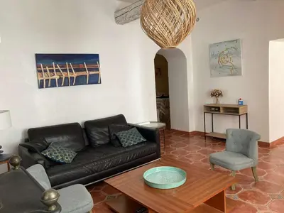 a living room with a black couch and a table at AIG 63 – Grande maison de village avec Wi-Fi – Gruissan – 13 personnes in Gruissan