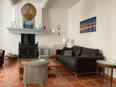 a living room with a couch and a stove at AIG 63 – Grande maison de village avec Wi-Fi – Gruissan – 13 personnes in Gruissan