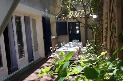 a patio with a table and chairs in a courtyard at AIG 63 – Grande maison de village avec Wi-Fi – Gruissan – 13 personnes in Gruissan