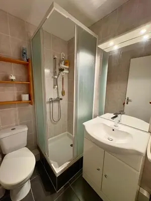 a bathroom with a shower and a toilet and a sink at Rez de jardin accès direct plage in Gruissan