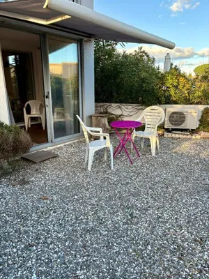 a purple table and chairs on a gravel patio at Rez de jardin accès direct plage in Gruissan