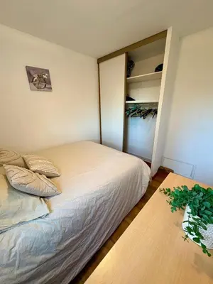 a small bedroom with a bed and a table at Rez de jardin accès direct plage in Gruissan