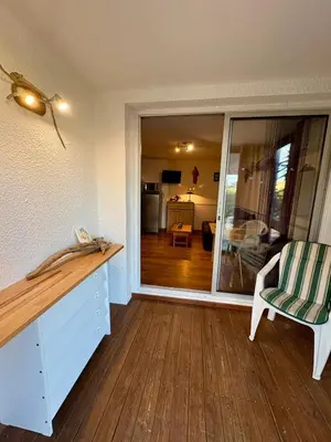 a room with a desk and a chair and a sliding glass door at Rez de jardin accès direct plage in Gruissan