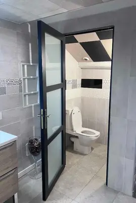a bathroom with a toilet and a glass door at Bel appartement, Deux chambres, Deux salles de bain in Vinassan