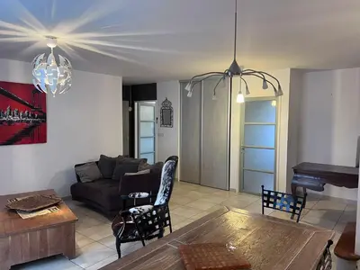 a living room with a couch and a table at Bel appartement, Deux chambres, Deux salles de bain in Vinassan