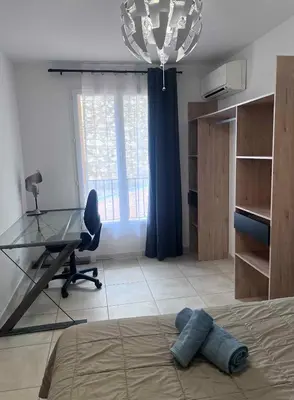 a bedroom with a desk and a bed and a desk and a window at Bel appartement, Deux chambres, Deux salles de bain in Vinassan
