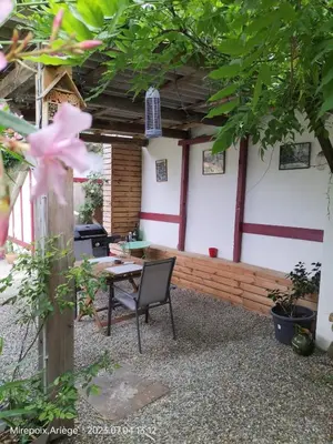 a patio with a table and a chair in front of a building at La Cave à Julie in Mirepoix