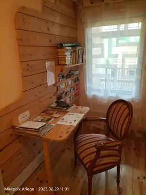 a wooden table and a chair in a room at La Cave à Julie in Mirepoix