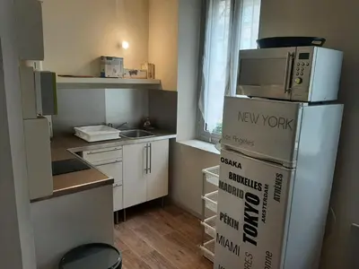 a kitchen with a refrigerator and a microwave on top of it at Studio Narbonne in Narbonne
