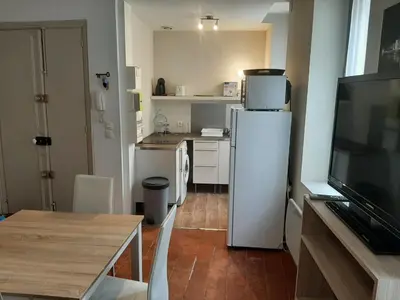 a kitchen with a white refrigerator and a table at Studio Narbonne in Narbonne