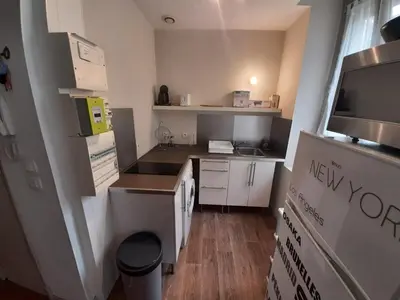 a small kitchen with white cabinets and a microwave at Studio Narbonne in Narbonne