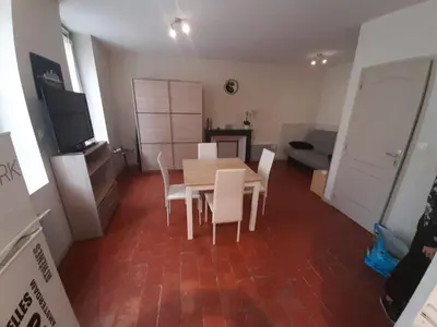a dining room with a table and chairs and a couch at Studio Narbonne in Narbonne