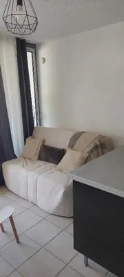 a living room with a large white couch in a room at Studio à proximité des plages in Gruissan