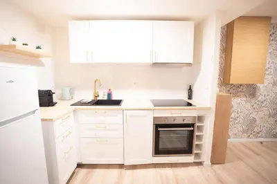 a white kitchen with a sink and a stove at Centre de Carcassonne 2min gare in Carcassonne