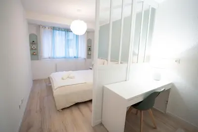 a small bedroom with a bed and a desk and a table at Centre de Carcassonne 2min gare in Carcassonne