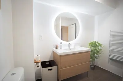 a white bathroom with a sink and a mirror at Centre de Carcassonne 2min gare in Carcassonne