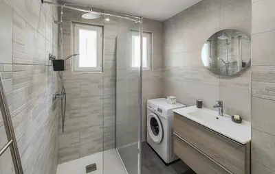 a bathroom with a washing machine and a sink at Maison calme avec vue sur les collines environnantes in Berlou