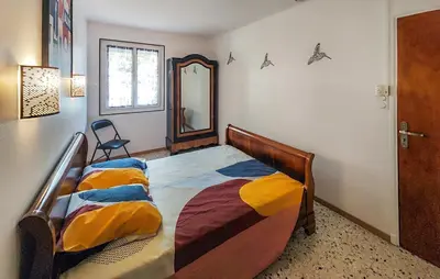 a bedroom with a bed with a mirror and a chair at Maison calme avec vue sur les collines environnantes in Berlou