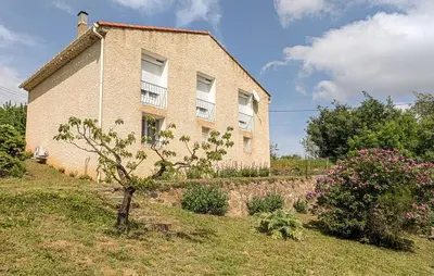 a brick house with a tree in front of it at Maison calme avec vue sur les collines environnantes in Berlou