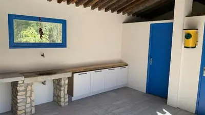 a kitchen with a counter and a blue door at Villa avec piscine, jardin de 8000m2, cuisine extérieur à 20min de Carcassonne in Arzens