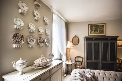 a living room with plates on the wall at Maison 1888 Carcassonne - Roof Terrace & Cité Views in Carcassonne
