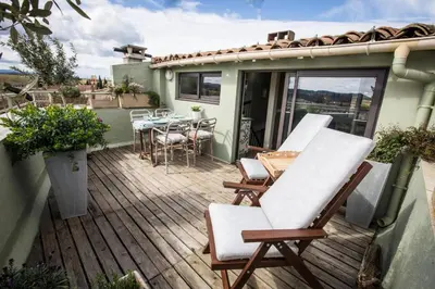 a deck with chairs and a table on a house at Maison 1888 Carcassonne - Roof Terrace & Cité Views in Carcassonne